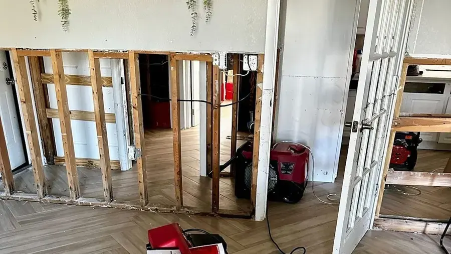 Walls opened to the studs with a dehumidifier drying the room after a water leak